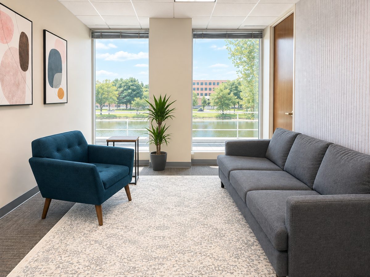 OnPoint Naperville office with a blue armchair, gray sofa, and large windows overlooking a pond